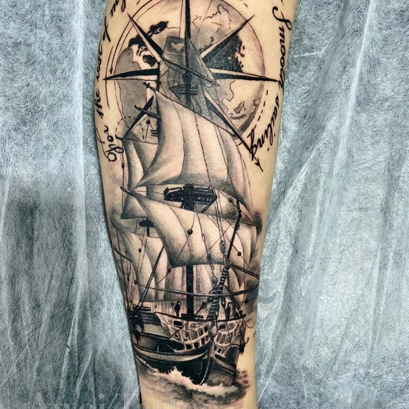 Black-and-grey sailing ship with compass rose temporary tattoo on forearm