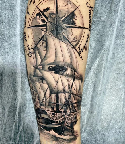 Black-and-grey sailing ship with compass rose temporary tattoo on forearm