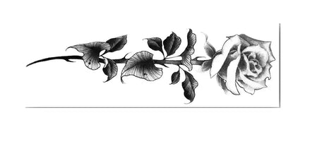 Vertical black-and-grey rose stem temporary tattoo with bold leaf shading on forearm