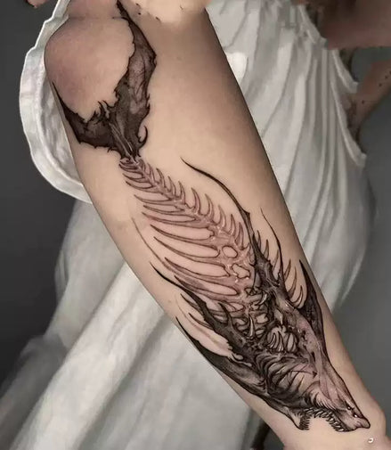 Forearm temporary tattoo: dragon skull and ribbed spine in blackwork, smoky wing detail; skin-safe herbal ink by MysticInk.